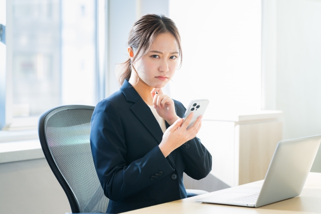 神妙な顔でこちらを見るスーツ女性
