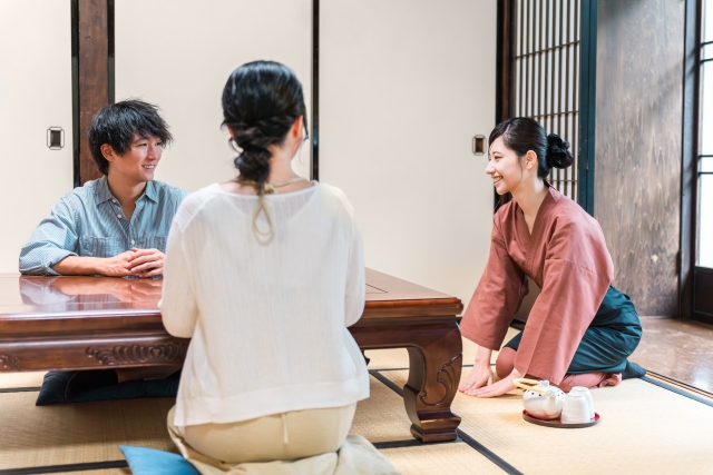 旅館の客室で挨拶する旅館スタッフの女性