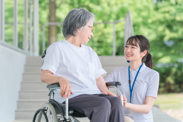 車椅子に乗った高齢者と介護士(ヘルパー)