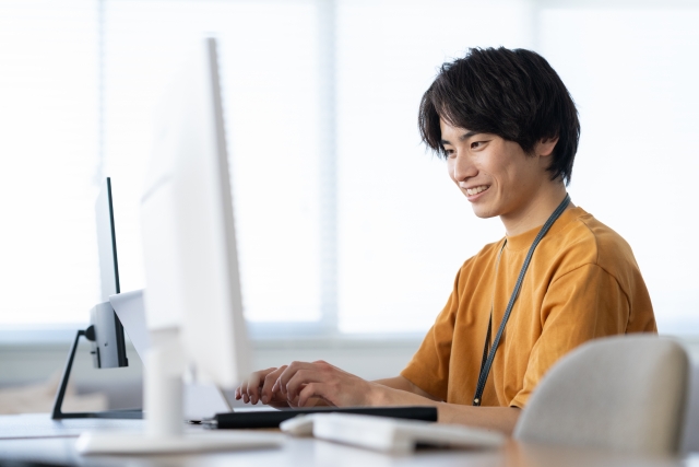 パソコンに向かってタイピングする男性