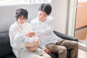 赤ちゃんを抱っこする女性と横に座る男性