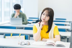 教室で悩む大学生