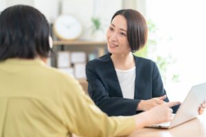 顧客に資料を見せるビジネスウーマン