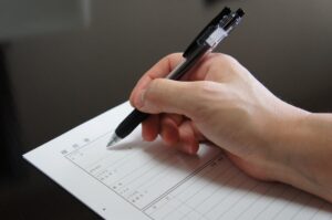 履歴書を書いている手