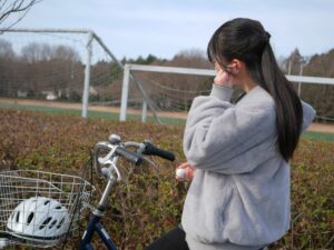 自転車に乗りイヤホンをする女性
